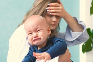 Bebé llorando en brazos de mamá